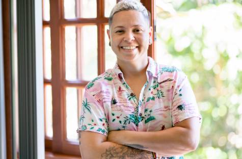 lgbtq person in a tropical shirt smiling