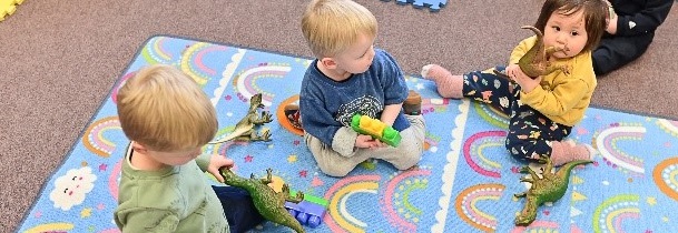 Children playing with toys on a playmat
