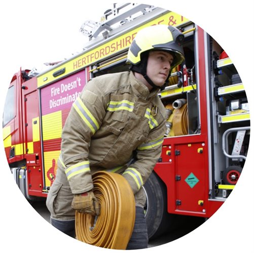 A firefighter reeling in a hose