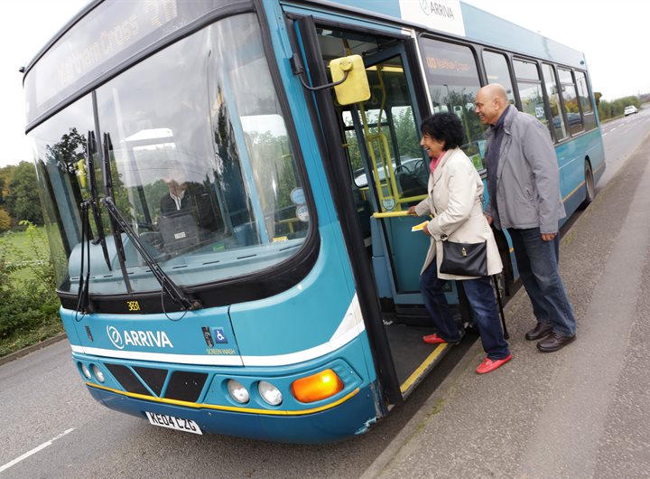 2 older people getting on a bus