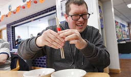 Young man using chopsticks