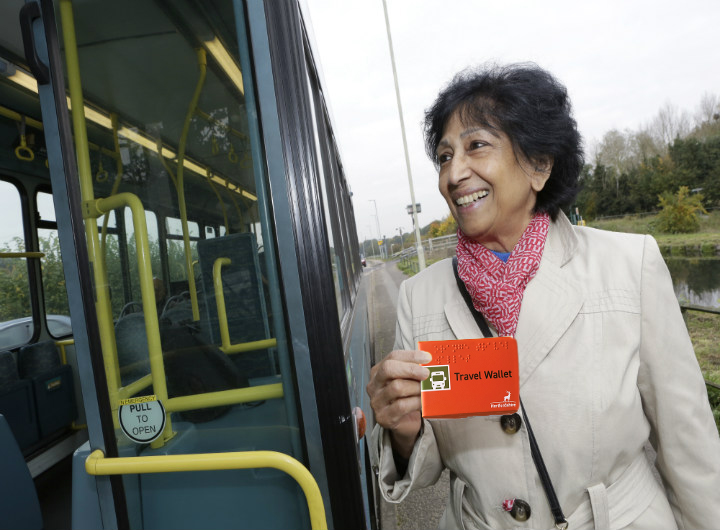 Lady with travel wallet getting on to a bus