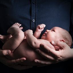 A baby being held by an adult