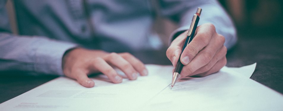Someone signing a form