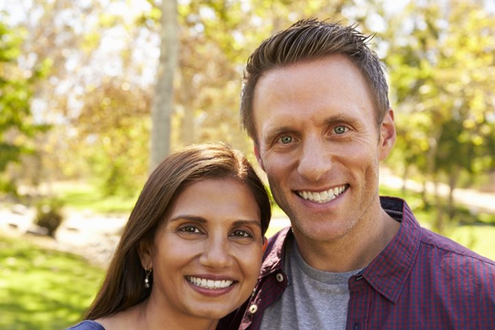 A couple smiling at the camera