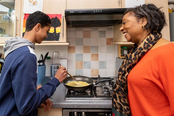 teenage boy cooking with carer
