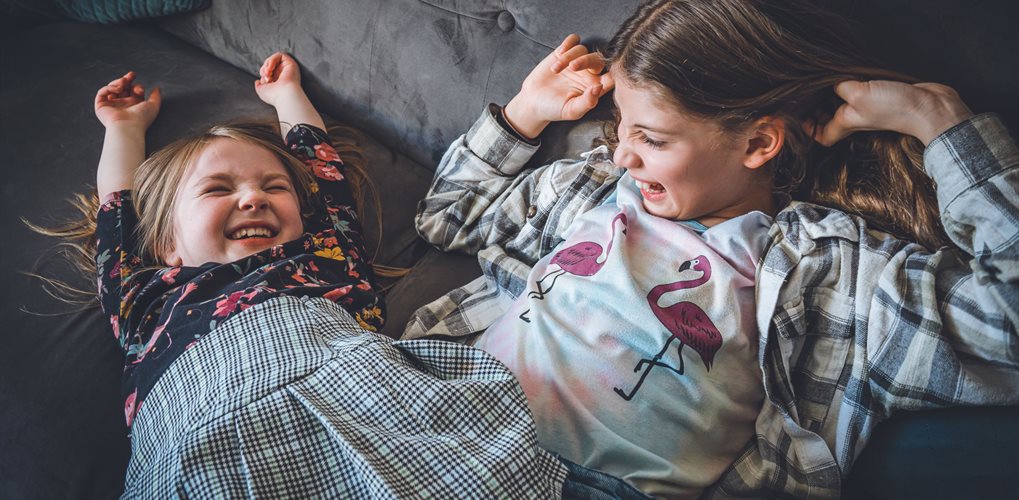 Two young sisters laughing together