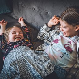 Two young sisters laughing together