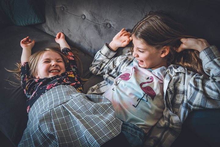 Two young sisters laughing together