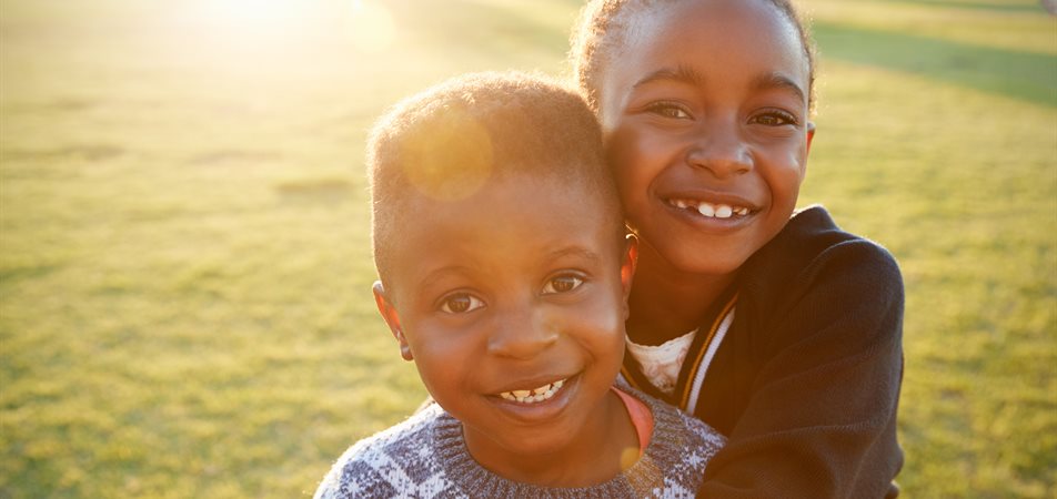 Girl and boy smiling and hugging