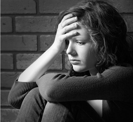 A young woman with her hand on her forehead