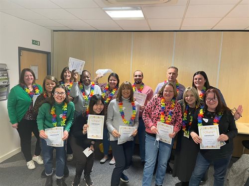 Ohana parent support volunteers standing in an office holding certificates and smiling.