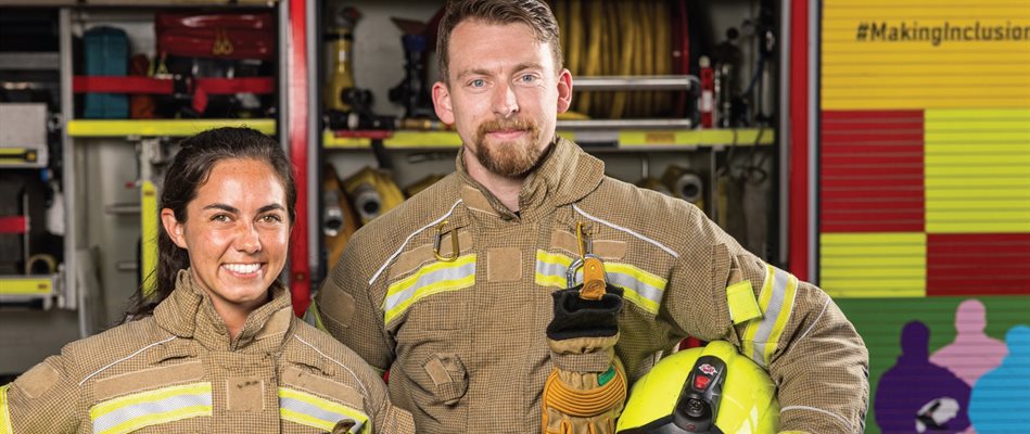 Fire fighters smiling in front of a fire engine