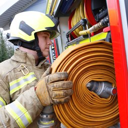 Firefighter reeling in a hose