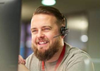 Male call agent smiling with headset on