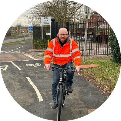 Man wearing a high vis jacket and riding a bike