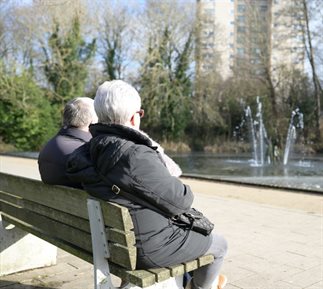 Two older people sitting on a bench