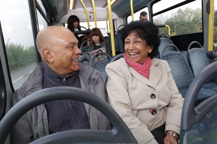 2 older people laughing on a bus