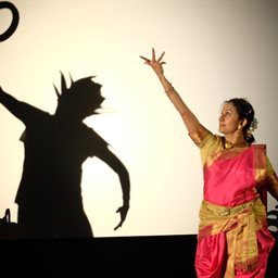 A woman dancing in front of a silhouette