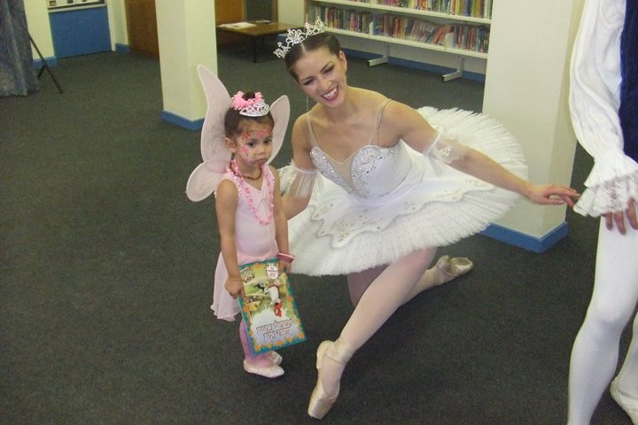 Ballerina with a young girl in a library