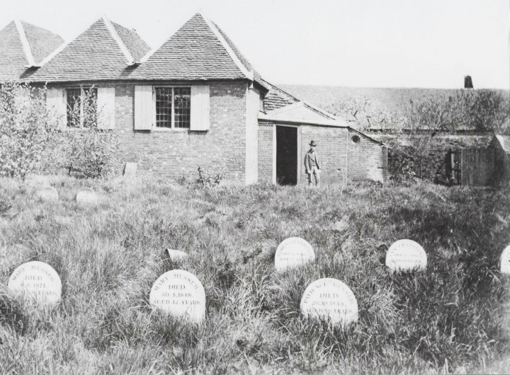 An old picture of a Quaker house and graveyard.