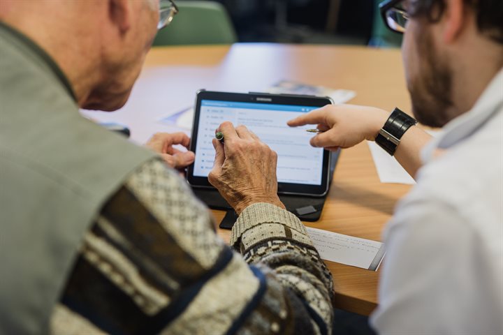 Librarian helping a man with a tablet