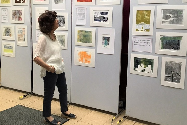 Sheila de Rosa looking at artwork on a gallery wall.