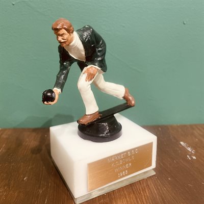 Person bowling with a smart green jacket