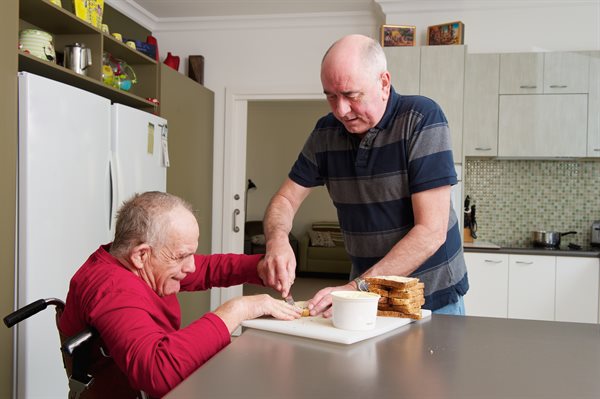 Home carer assisting man with disability