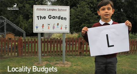 L - kid holding up letter