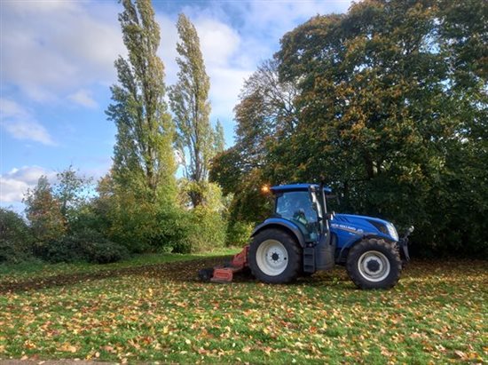 a blue tractor preparing the ground for wildflowers to be planted
