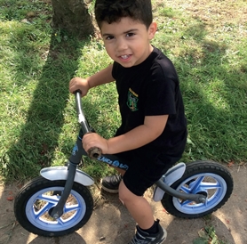 Hollybush Primary School student with a donated balance bike