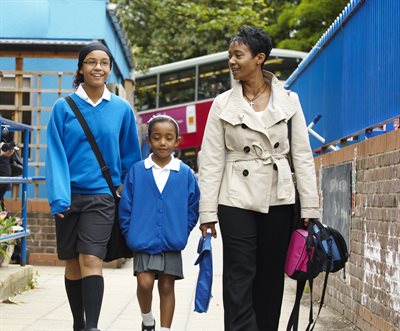 Mother and two daughters walking to school.