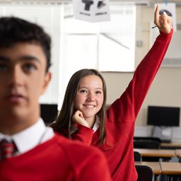 School girl raising her hand in class