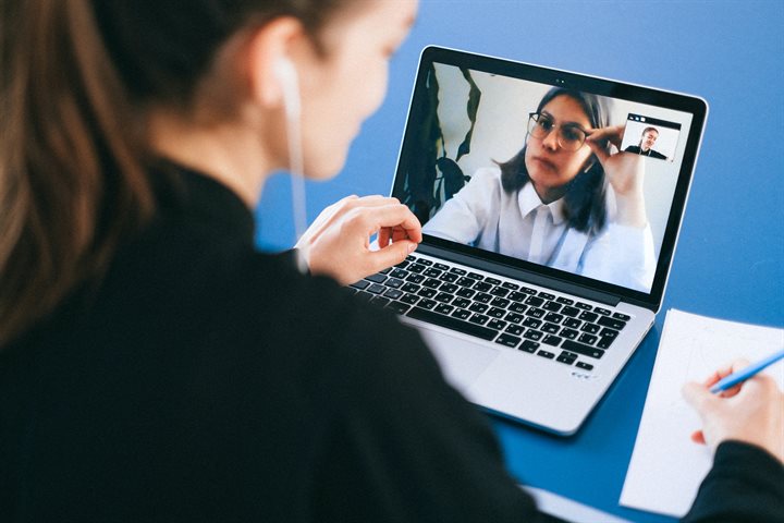 Two women on a video conference call via laptop