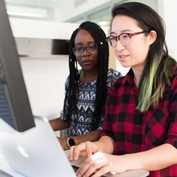 2 people looking at a macbook