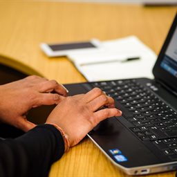 Woman's hands typing on a keyboard