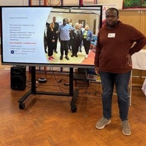 CJ standing in front of a presentation screen