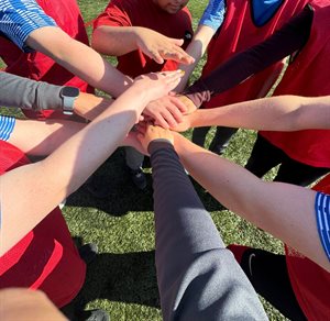 group of people with hands all joining together in the middle
