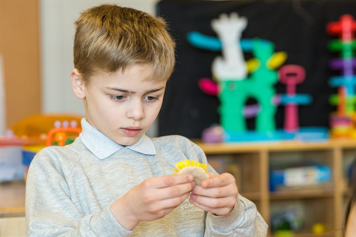 Primary aged boy concentrating at school on his artwork